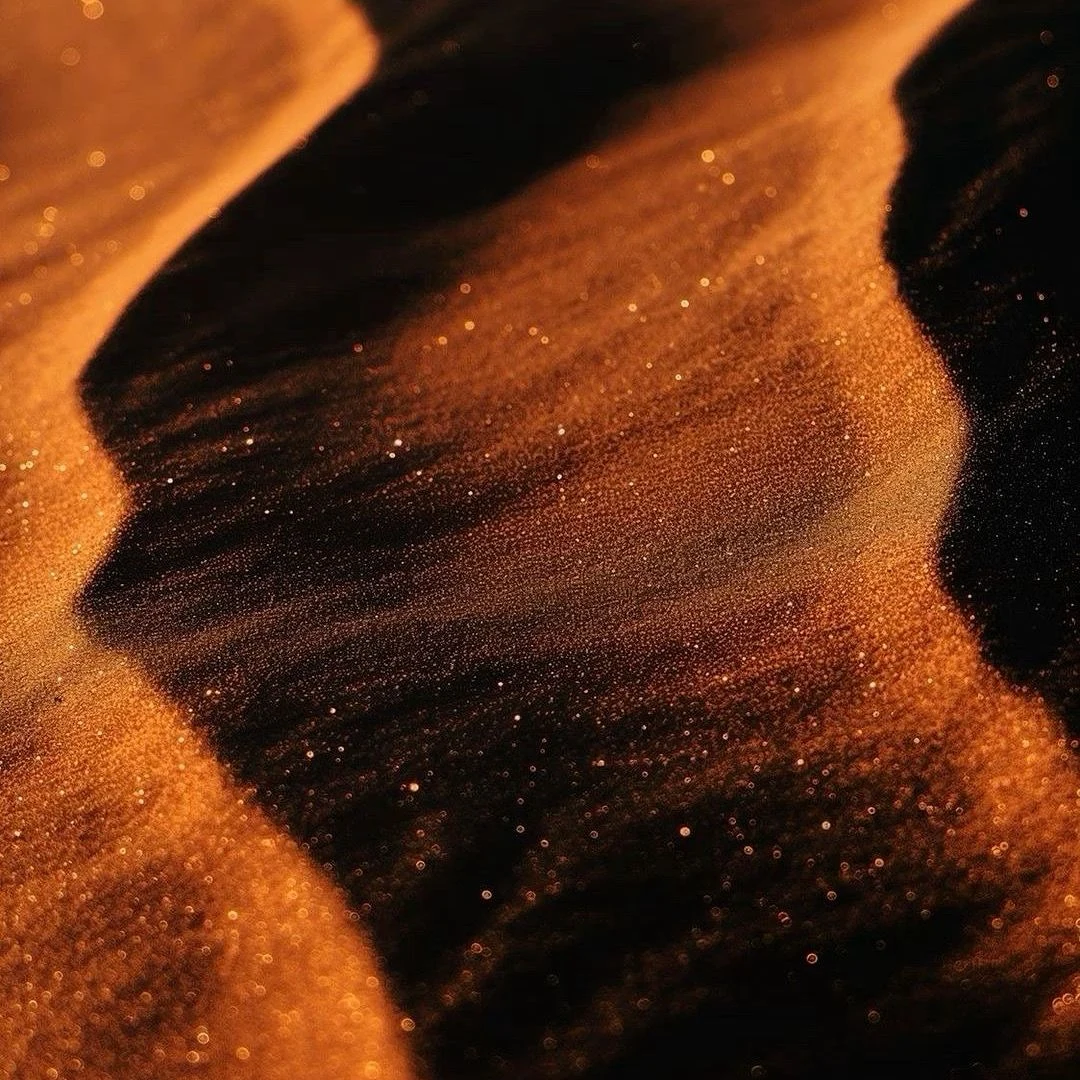 Golden sand with sweeping ripples and shadows